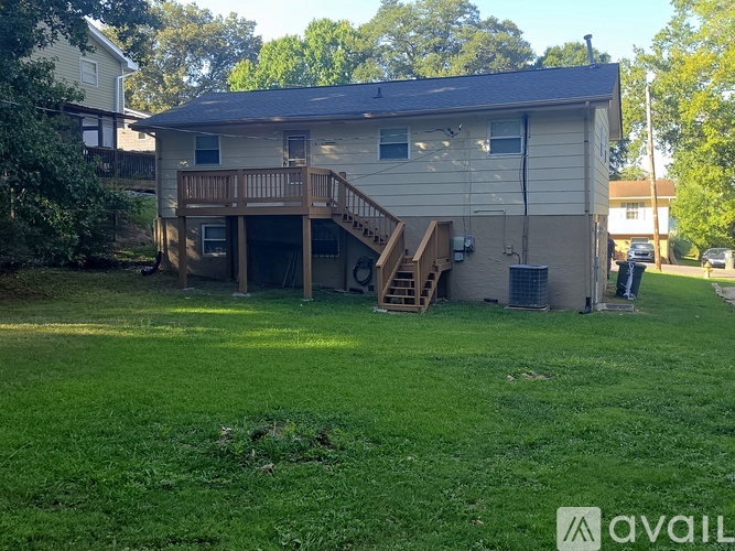 A house with a deck and stairs leading to a garage.