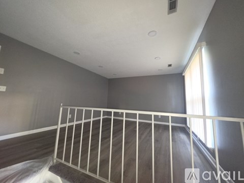 A white metal bed frame in a room with grey walls.