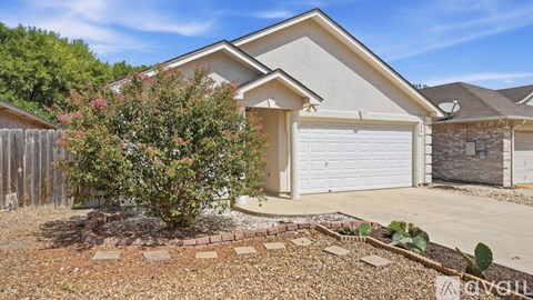 A house with a white garage door and a small garden in front.