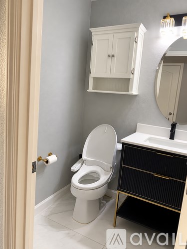 A bathroom with a toilet, sink, and medicine cabinet.