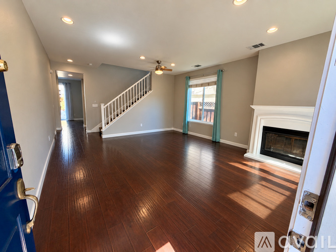 A living room with a fireplace and a staircase.