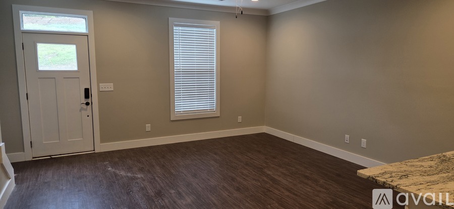 A room with a door and a window with blinds.