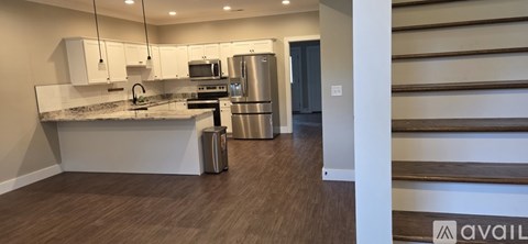 A kitchen with a granite countertop and stainless steel appliances.