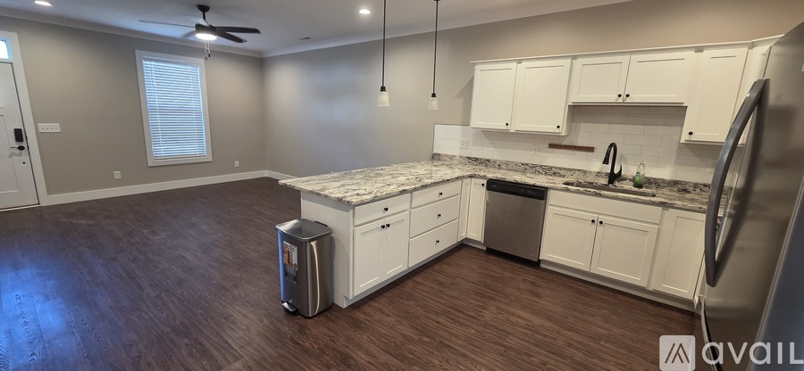 A kitchen with white cabinets and a marble countertop.