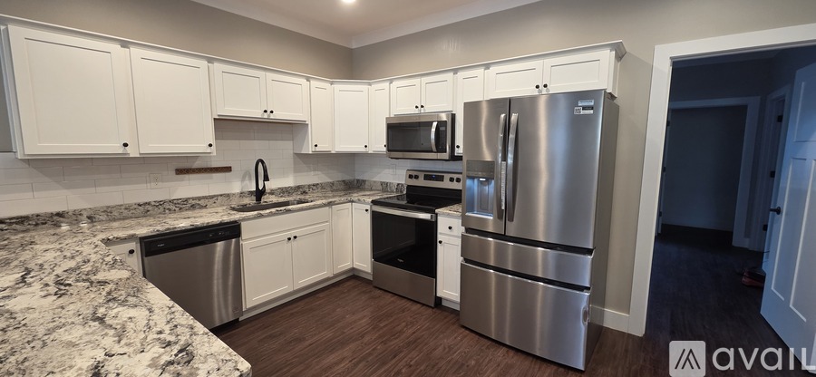 A kitchen with white cabinets and a granite countertop.