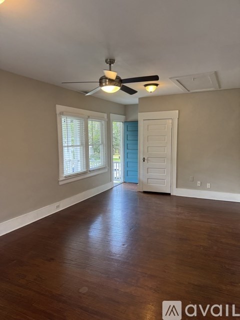 A room with a ceiling fan and wooden flooring.