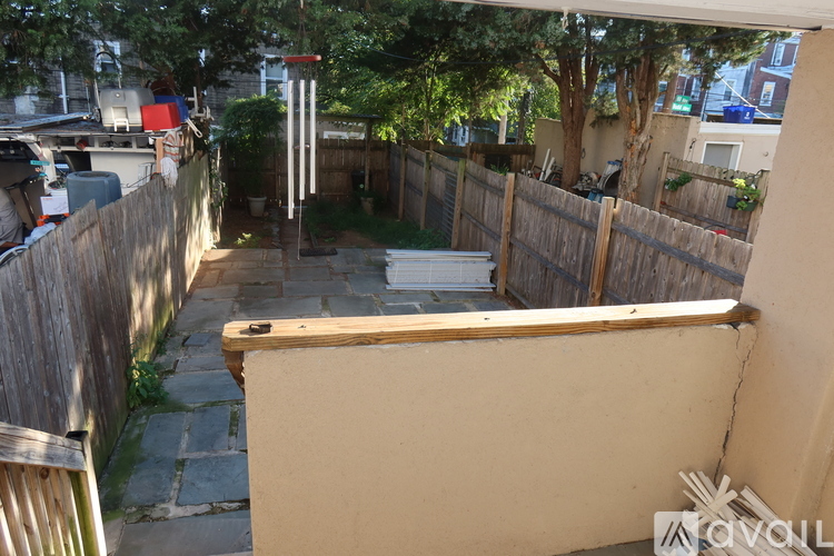 A backyard with a wooden fence and a stone pathway.