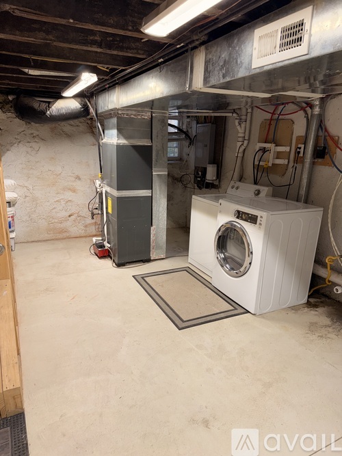 A dirty basement with a washing machine and a dryer.