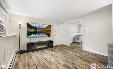 A living room with a large painting of a lake and mountains on the wall.