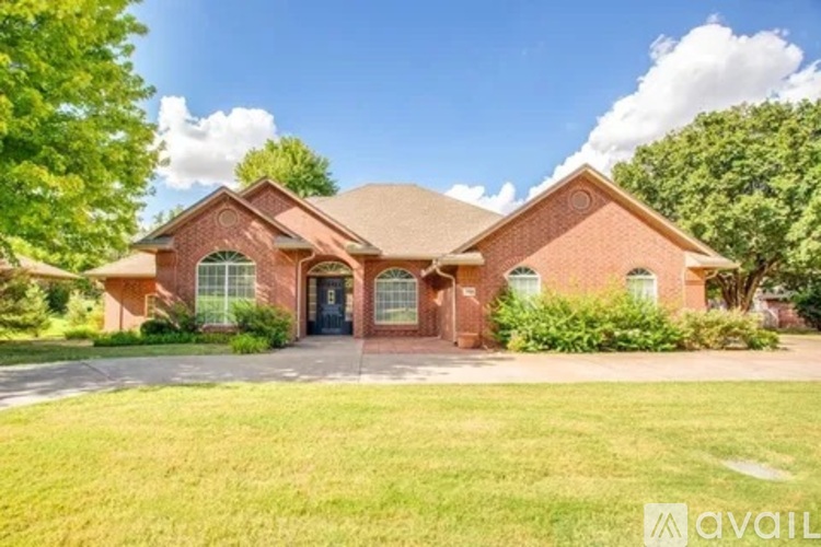 A house with a red brick exterior and a large front yard.