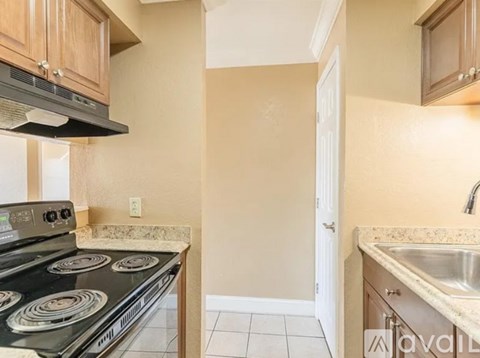 A kitchen with a black stove top oven and a white door.