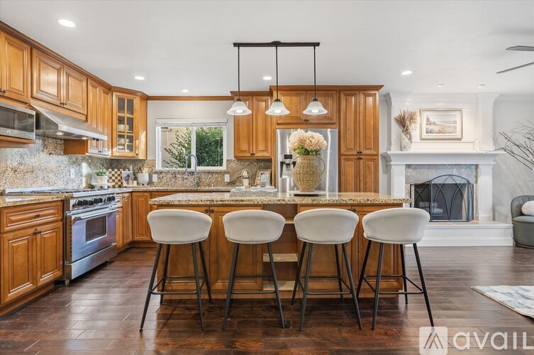 A kitchen with wooden cabinets and a marble backsplash.