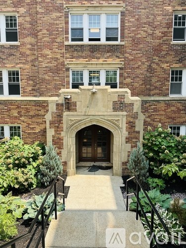 A brick building with a large arched entrance and steps leading up to it.