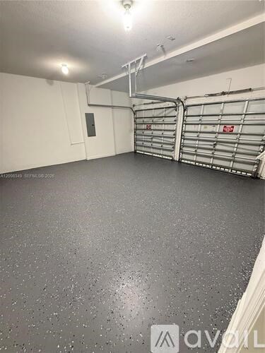 A spacious garage with grey flooring and metal racks.