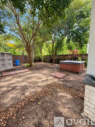 A backyard with a dirt ground and a few trees.