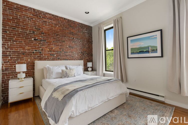 A bedroom with a brick wall and a large bed.