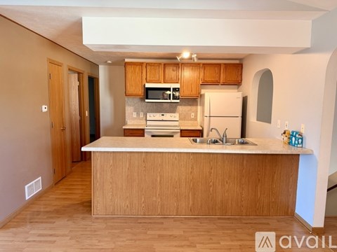 A kitchen with wooden cabinets and a white refrigerator.