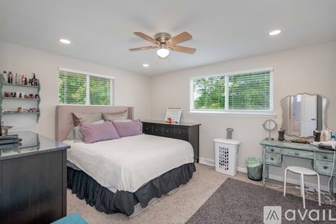 A bedroom with a bed, desk, and chair.