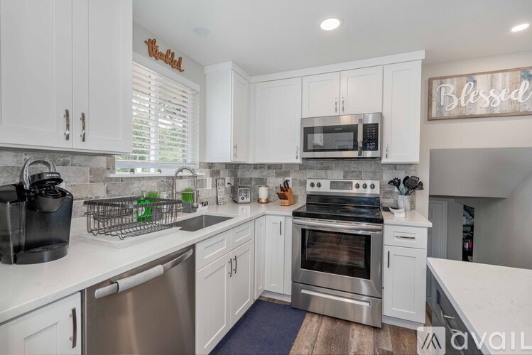 A kitchen with white cabinets and a stainless steel oven.