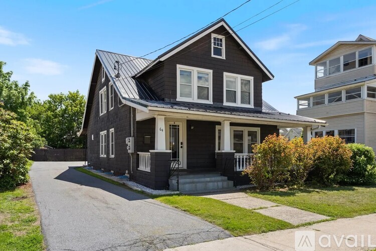 A two-story house with a grey exterior and a white door.