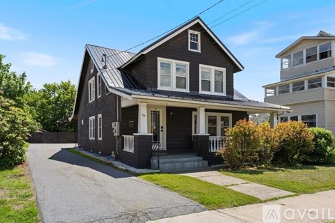 A two-story house with a grey exterior and a white door.