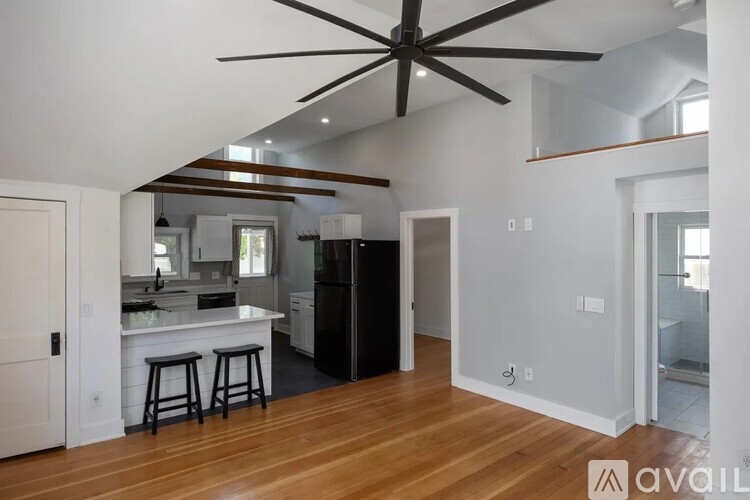 A kitchen with white cabinets and a black fridge is shown.