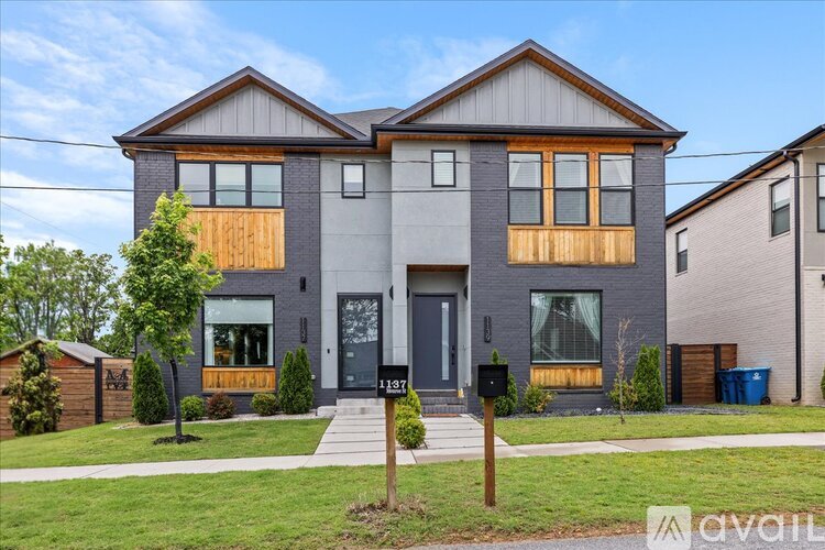 A two-story house with a grey exterior and wooden accents.