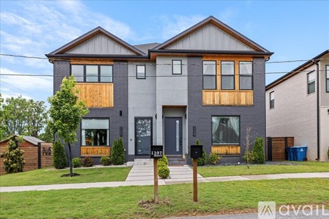 A two-story house with a grey exterior and wooden accents.