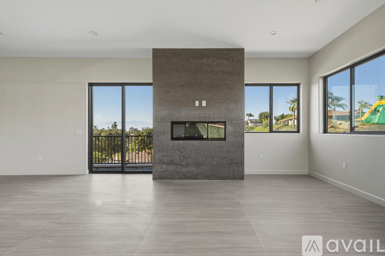 A modern living room with a fireplace and large windows.