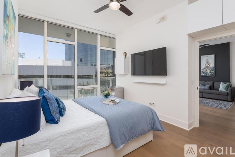 A bedroom with a large bed and a flat screen TV mounted on the wall.