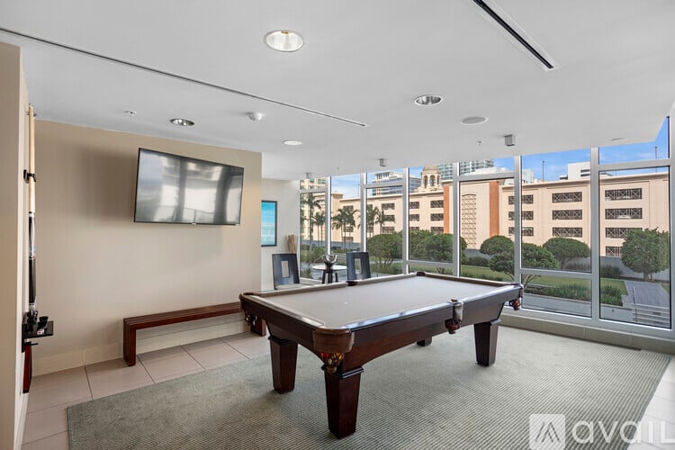 A room with a pool table and a television.