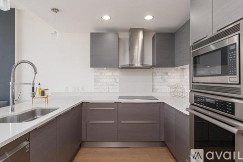 A modern kitchen with a stainless steel oven and microwave.