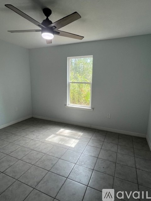 A room with a ceiling fan and a window.