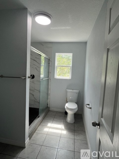 A bathroom with a toilet and a glass shower door.