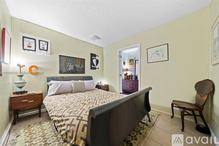 A bedroom with a large bed and a chair.