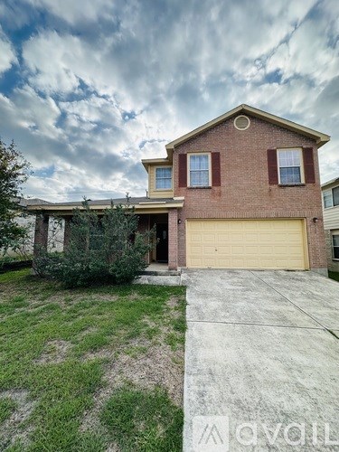 A house with a garage and a driveway in front of it.
