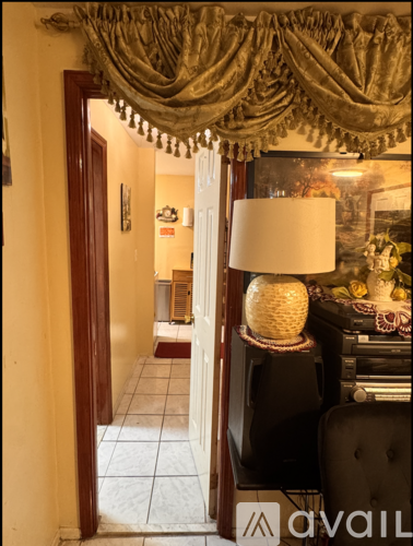 A lamp on a table in a room with a doorway leading to another room.