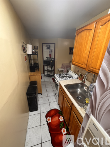 A kitchen with wooden cabinets and a white tiled floor.