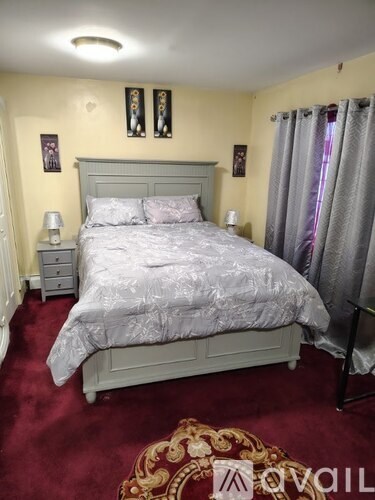 A bedroom with a large bed and a red carpet.