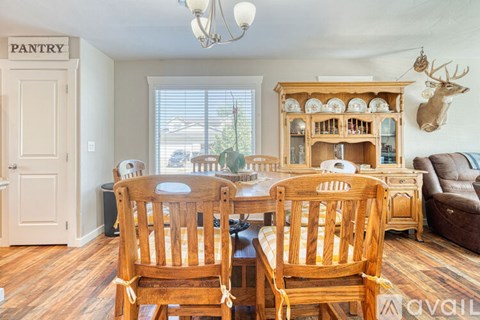 A dining room with a pantry door and a deer head on the wall.