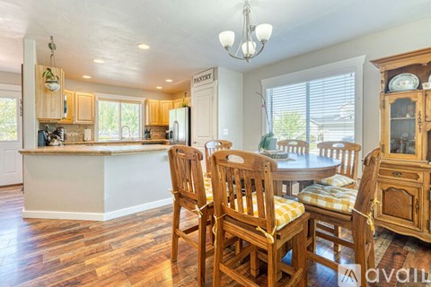 A kitchen with wooden chairs and a dining table.