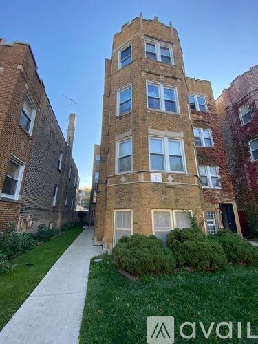 A tall brick building with a walkway in front of it.