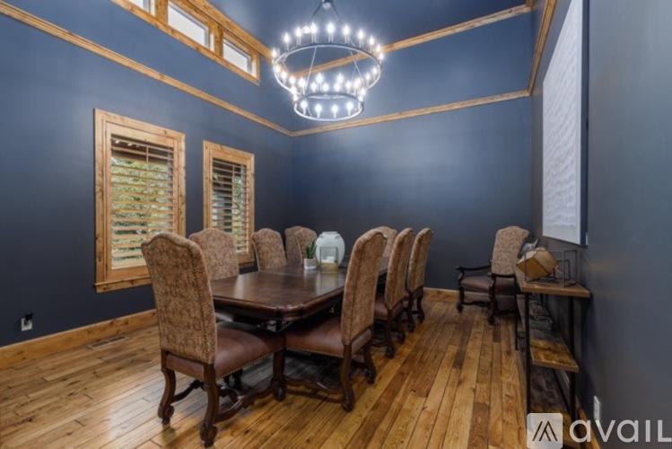 A dining room with a large table and chairs.