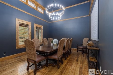 A dining room with a large table and chairs.
