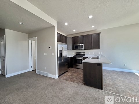 A kitchen with dark brown cabinets and a white countertop.