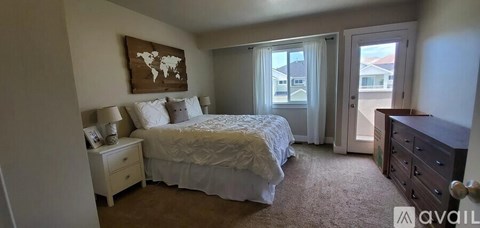 A bedroom with a large bed and a world map on the wall.