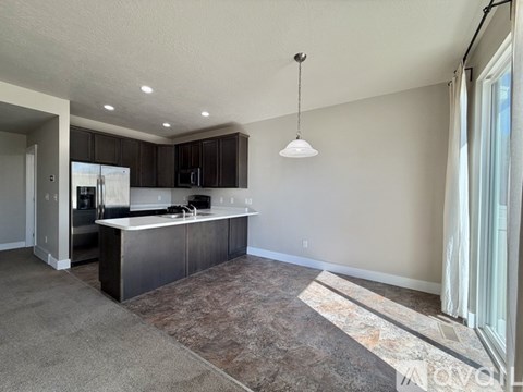 A kitchen with dark brown cabinets and a white countertop.