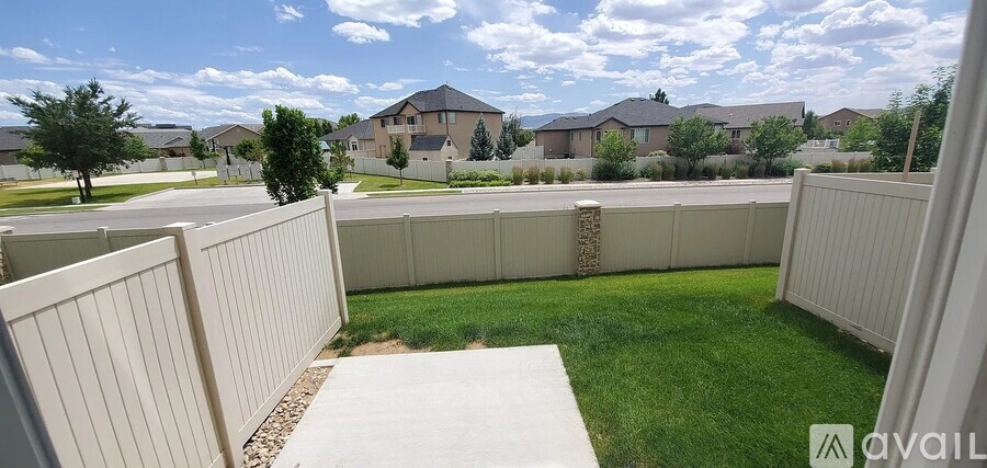 A white fence in a grassy area with a house in the background.