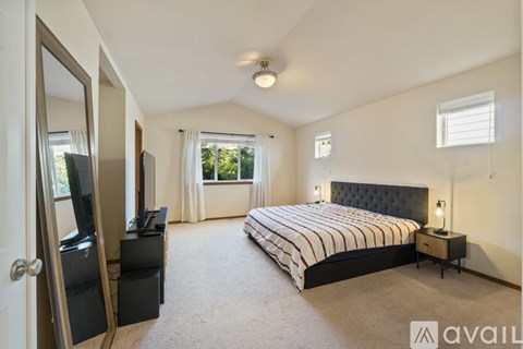 A bedroom with a large bed and a flat screen TV.