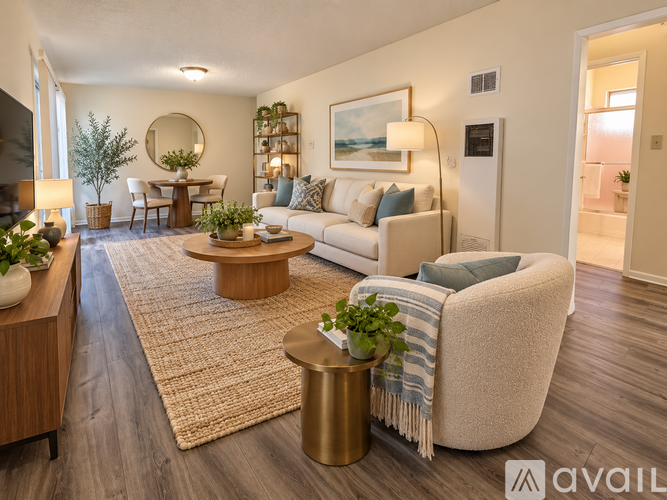 A living room with a white couch, a coffee table, and a round mirror on the wall.